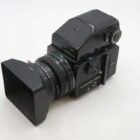A black medium format camera with a square lens hood, featuring the brand name "Bronica" on the body and lens.