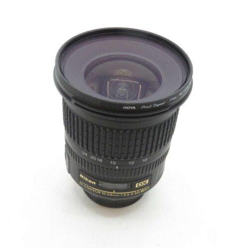 Nikon DX AF-S NIKKOR 10-24mm f/3.5-4.5G ED black camera lens with visible focus and zoom rings, and a Hoya Pro1 Digital 77mm lens filter attached, standing upright against a white background.