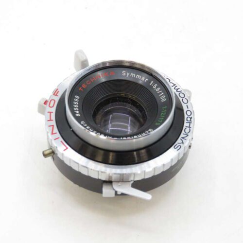 A close-up of a Linhof Technika Synchro-Compur camera lens with visible dials and inscriptions.