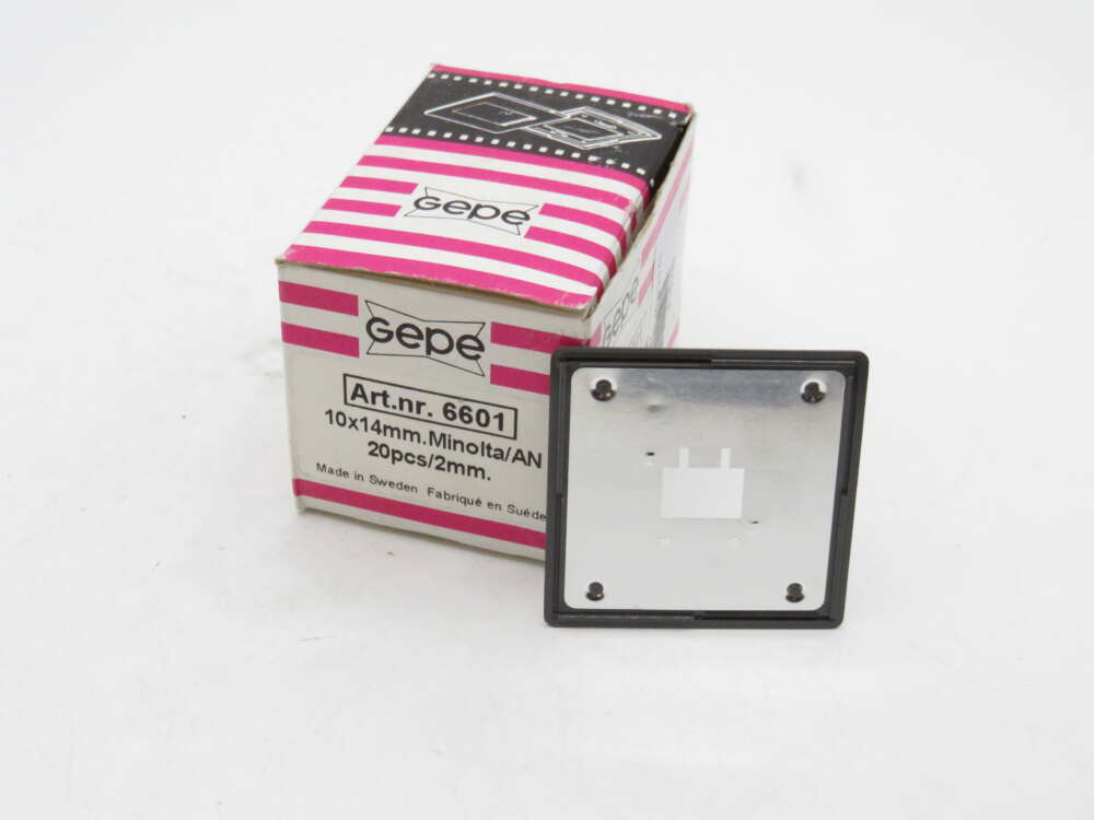 IMG_2282 A Gepe slide mount box with model number 6601 next to an individual slide mount plate on a white background. The box is pink and white with product details written on it, including size specifications of 10x14 mm for Minolta or AN, and indicates contents of 20 pieces per 2 mm pack.