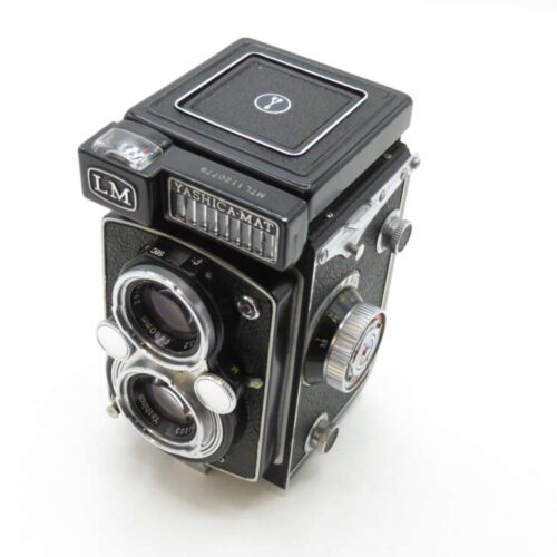 A vintage Yashica-Mat LM twin-lens reflex camera with a black body, featuring two lenses and various dials on the side.