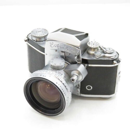 A vintage Exakta Varex IIa camera with a large lens, featuring a classic silver and black design, placed on a white background.