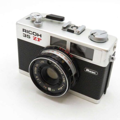 A vintage Ricoh 35 ZF film camera with a silver top, black body, and a Ricoh lens.