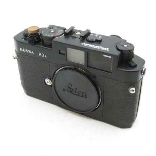 A black Bessa R3A rangefinder camera with a Voigtländer logo and a Leica lens cap.