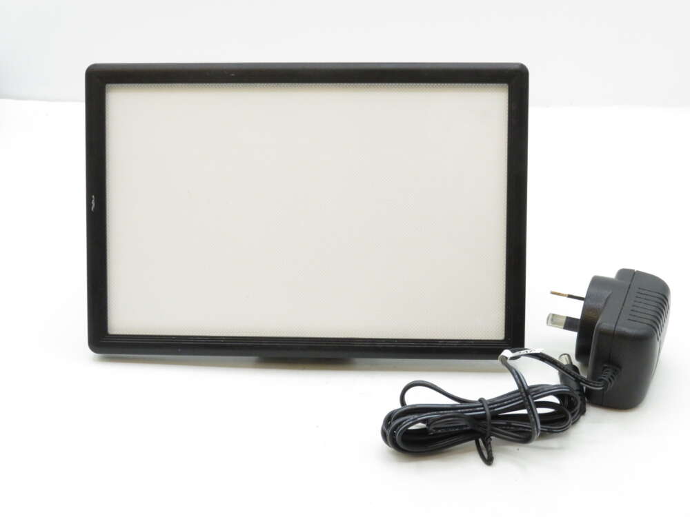 IMG_3196 Rectangular LED light panel with a black frame, accompanied by a power adapter with a plug.