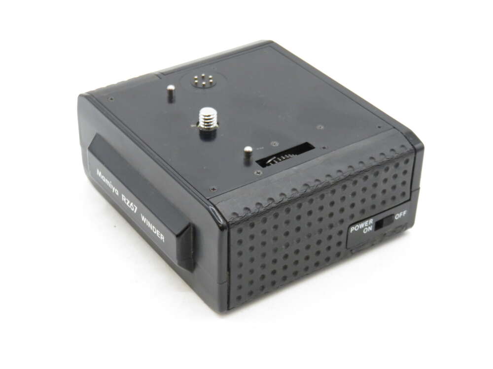 IMG_3332 A rectangular black Minolta motor drive with a power switch and textured surface.