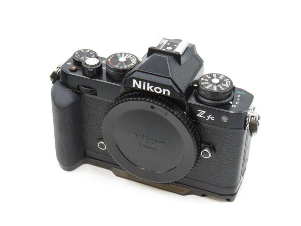 IMG_3504 A black Nikon Z fc camera with various control dials and a textured grip, viewed from the top and slightly from the front.