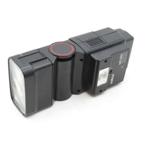 A vintage Sekonic electronic flash with a rectangular lens and control panel, featuring a red circular button.