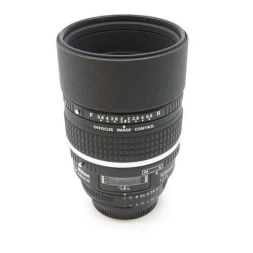 A Nikon camera lens with defocus image control settings, featuring a textured grip and marked aperture values.