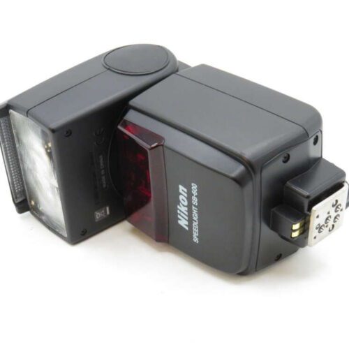 A Nikon Speedlight SB-800 flash unit lying on its side, showing the flash head and control buttons.