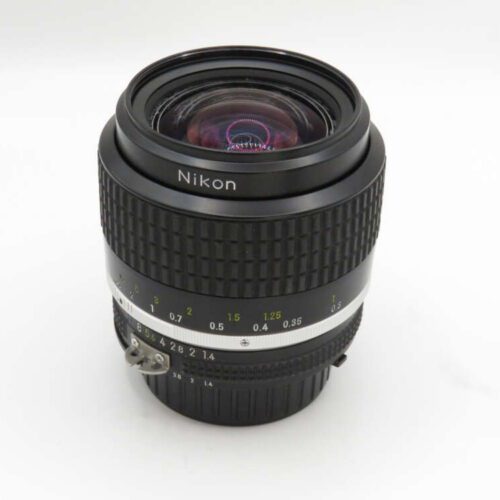 Nikon camera lens with a black body, focus rings, and distance markings, positioned against a plain white background.
