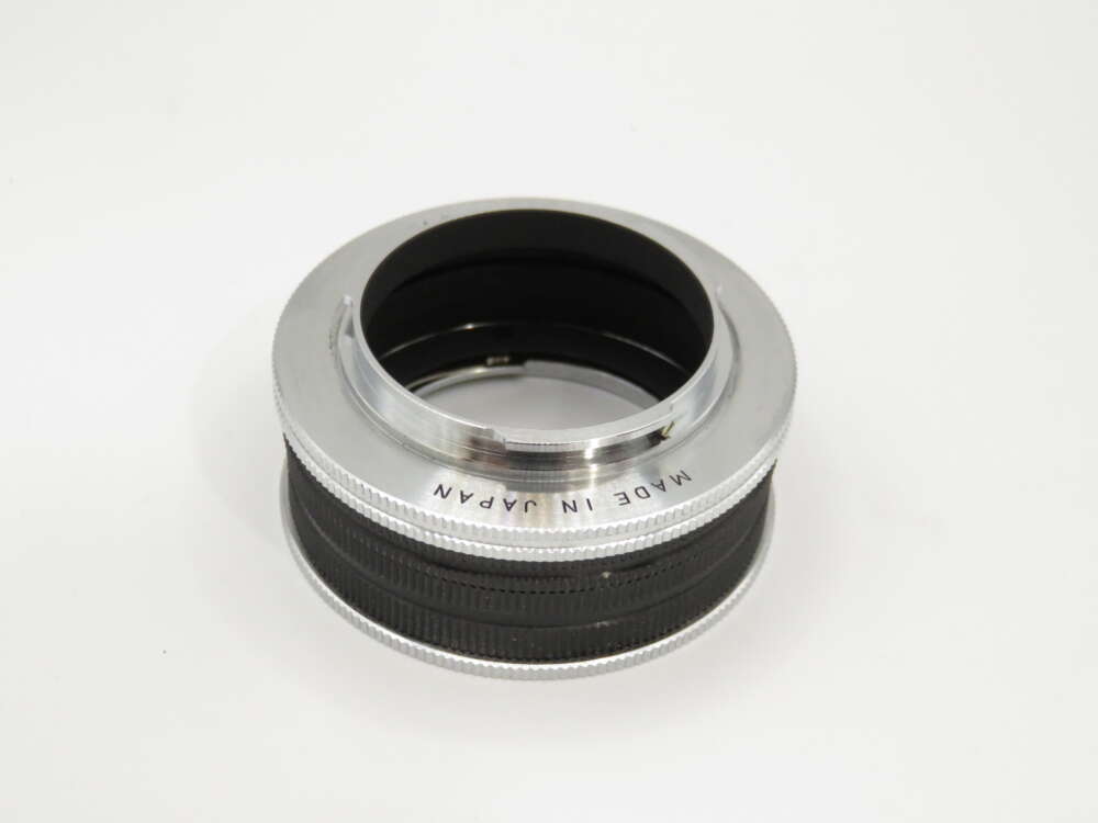 IMG_3828 A camera lens adapter with "Made in Japan" engraved on the silver rim, featuring a black inner ring.