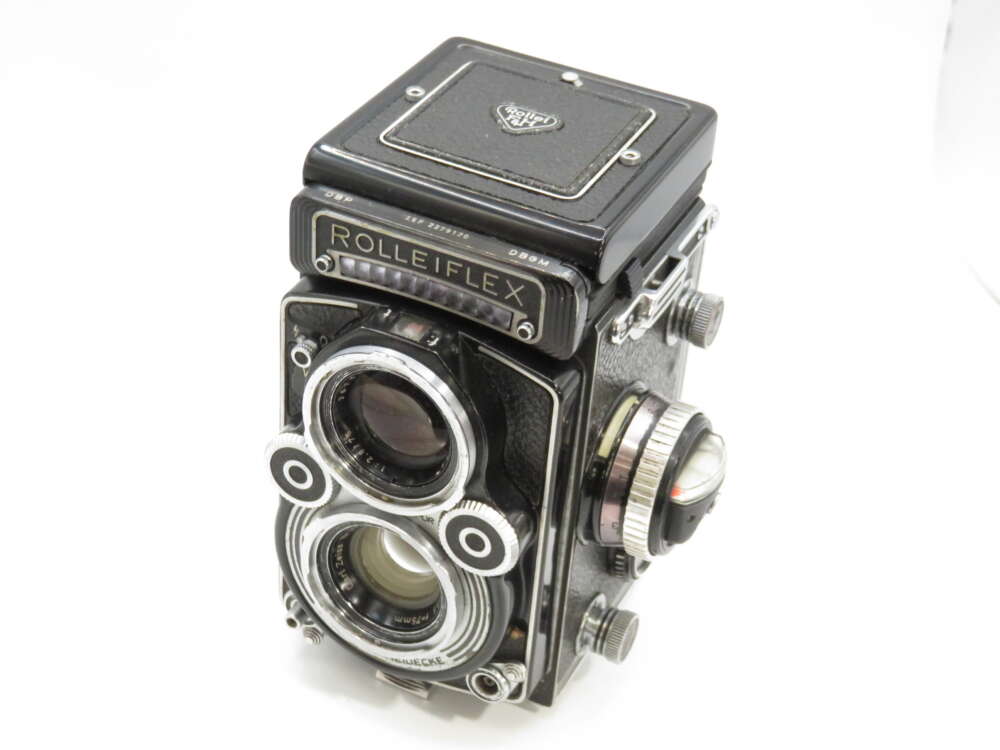 IMG_3863 A vintage Rolleiflex twin-lens reflex camera with a black body and silver detailing, featuring two prominent lenses on the front.