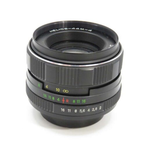 A Helios-44M-4 camera lens with focus and aperture rings, marked with white, green, and red numbers.