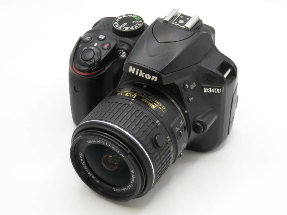 IMG_4012 A Nikon D3400 DSLR camera with a 70-300mm lens attached, angled slightly to show its controls and logo.