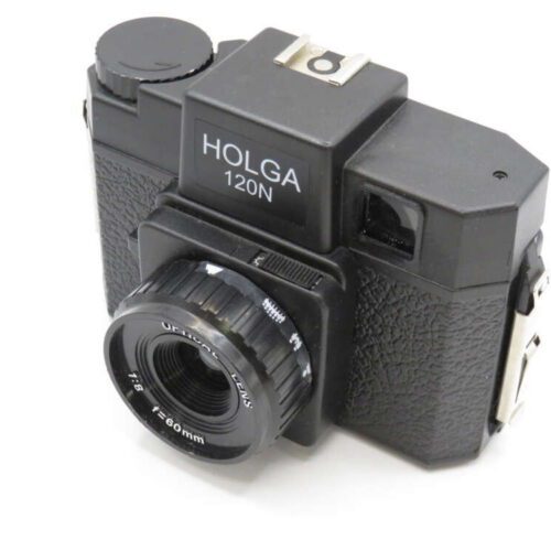 Black Holga 120N medium format film camera with a lens cap and textured grip, viewed at an angle.