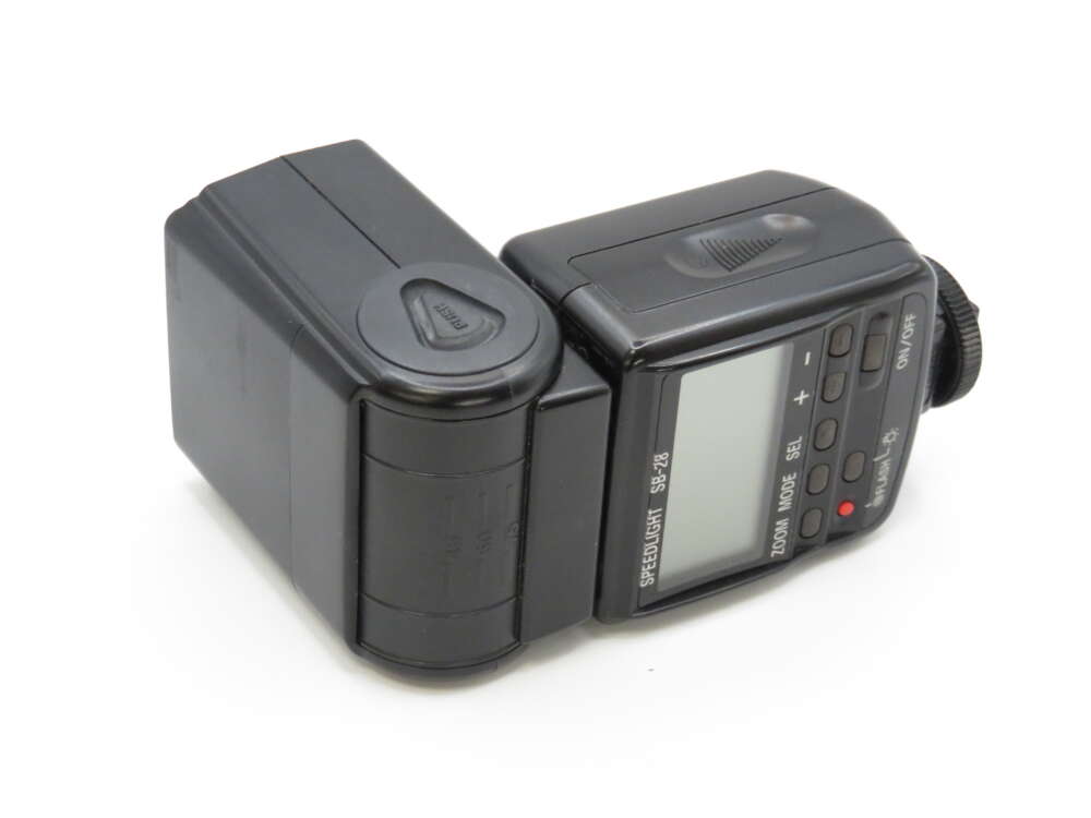 IMG_4030 A black camera flash unit with buttons, a display screen, and a rotating head.