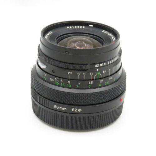 A 50mm camera lens with manual focus and aperture settings, featuring distance and aperture scales in green and white markings.