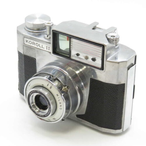 A vintage Koroll II camera with a metal body and black textured grips, featuring a prominent lens and viewfinder.