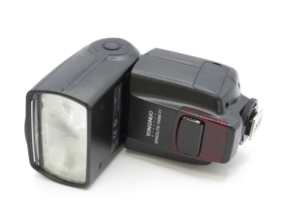IMG_4138 A Yongnuo Speedlite YN560-IV external camera flash with a rectangular shape and control buttons.