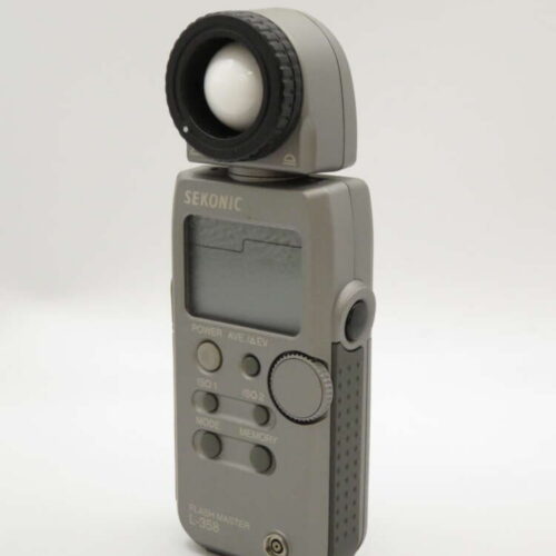 A grey Sekonic L-358 light meter with an adjustable sensor and several control buttons on the front.