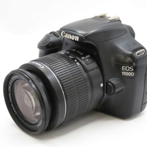 A black Canon EOS 1100D DSLR camera with a lens attached, angled to show the lens and part of the body.