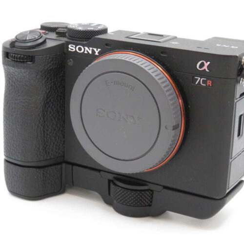 A black Sony α7CR camera with a textured grip and lens cap, featuring prominent brand and model markings.