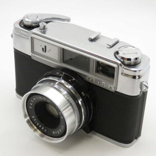 A vintage Yashica camera with a rangefinder design, featuring a silver and black body with a prominent lens and dials.