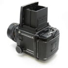 Vintage medium format camera with a waist-level viewfinder and prominent lens, angled to show the side and rear.