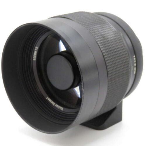 A black camera lens with textured grip, wide front element, and markings near the lens edge.